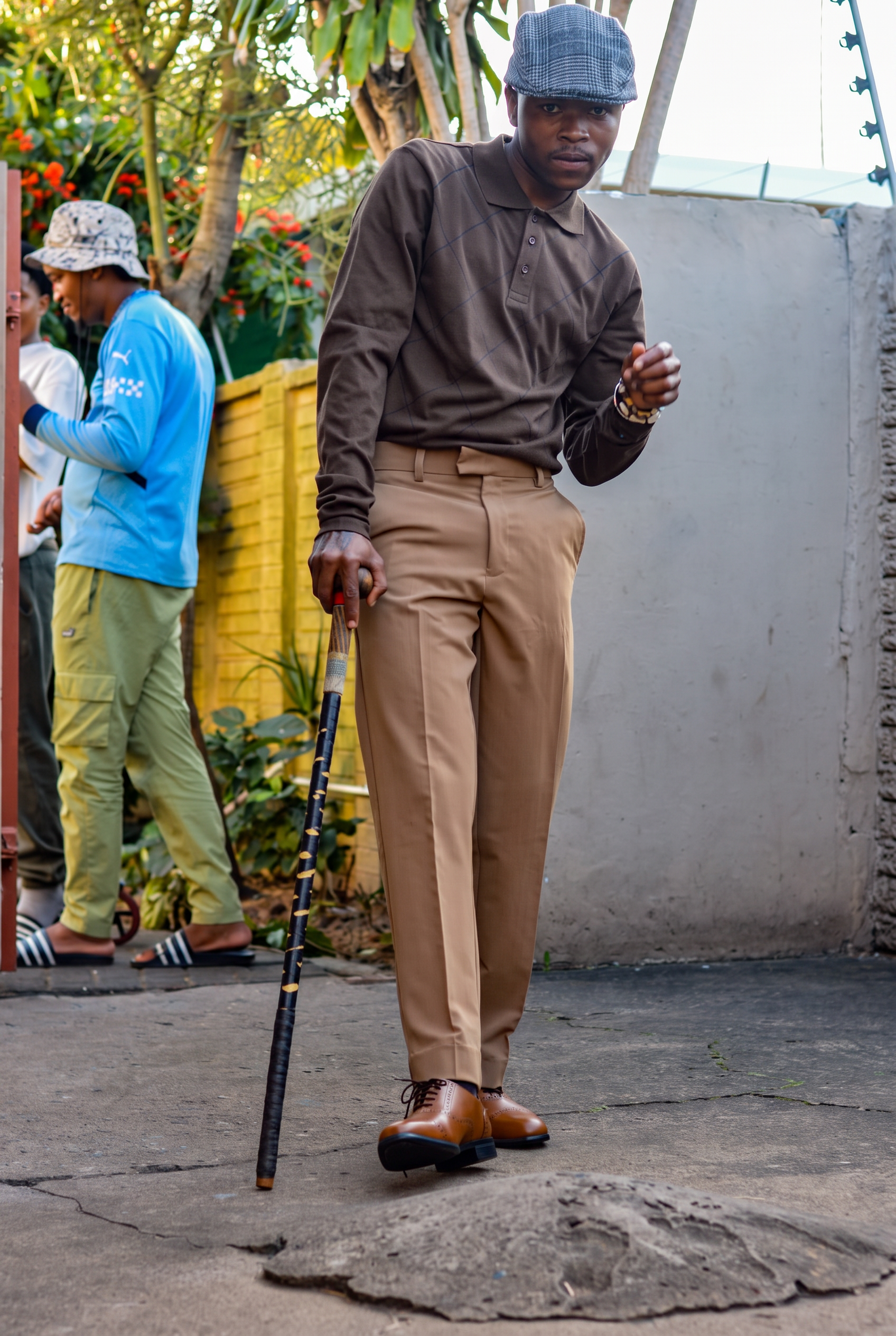 LatshuZAR posing on the street with a walking stick